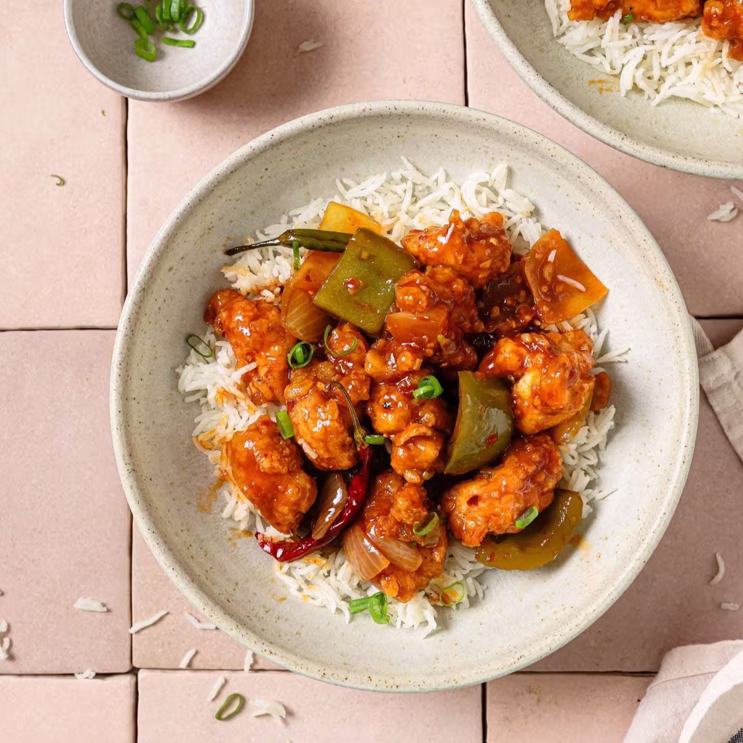 A warm bowl of chicken chili topped with cilantro and sliced peppers, showing rich color and texture
