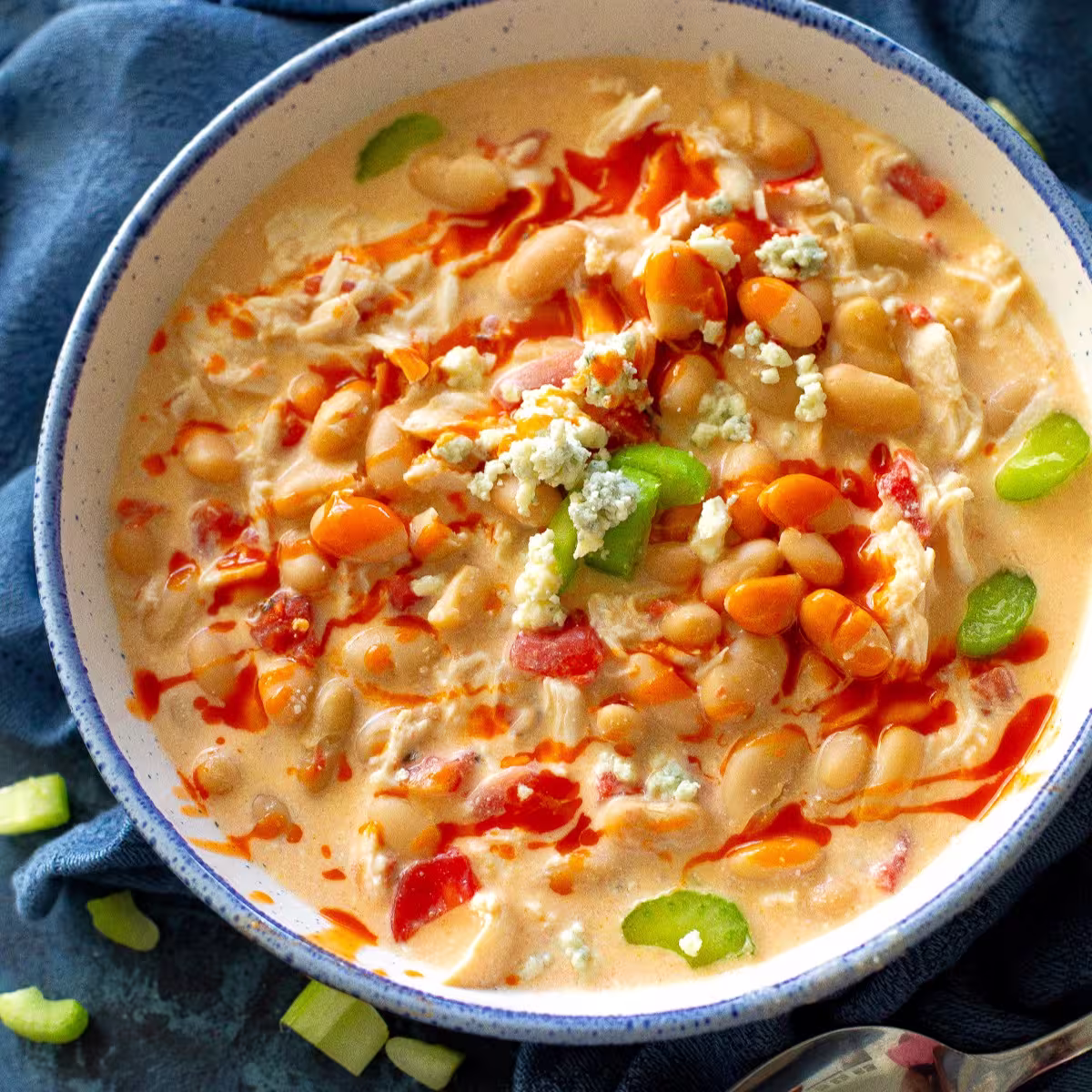 A pot of slow-cooked white chicken chili simmering with beans, shredded chicken, and spices.